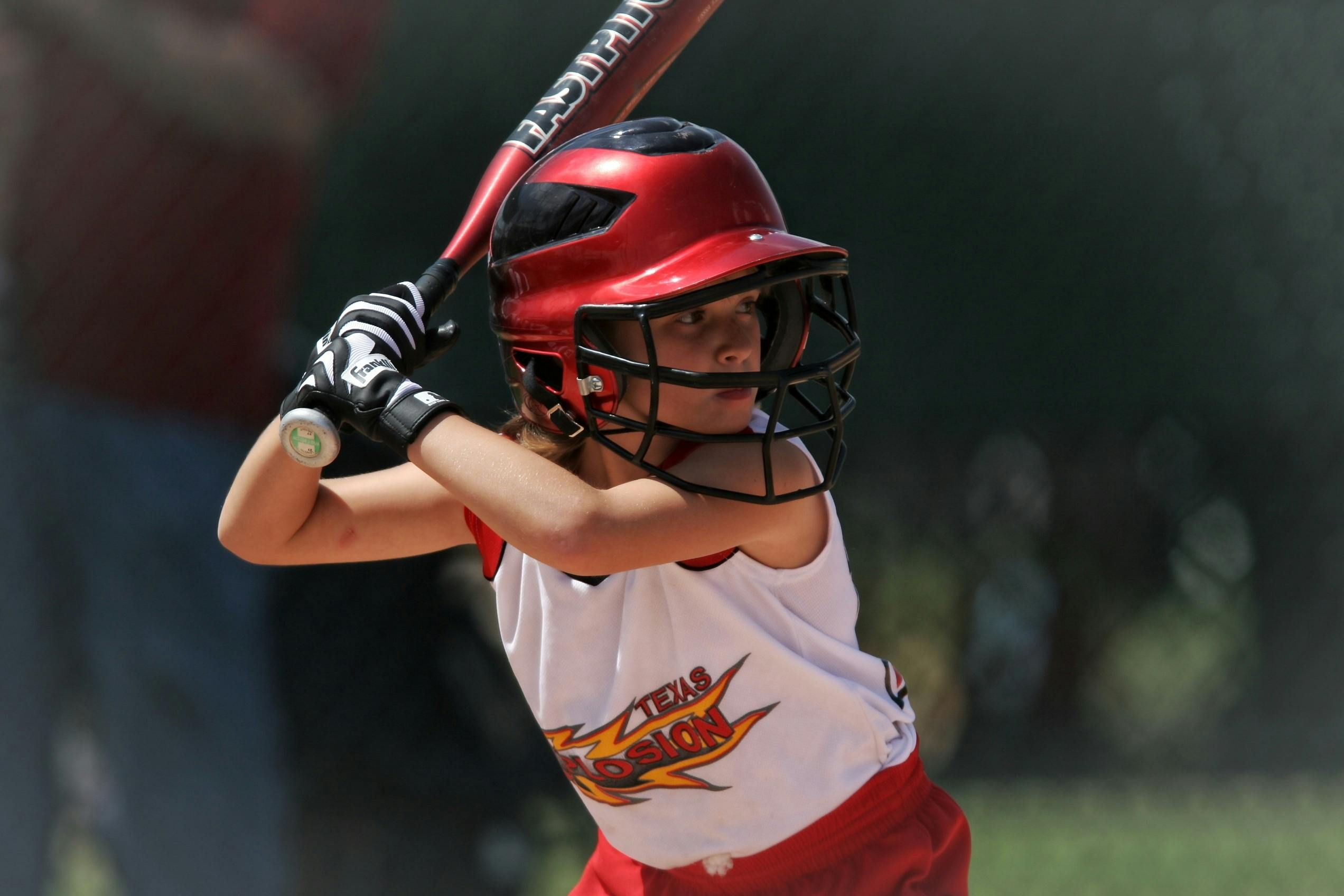 Young softball player batting